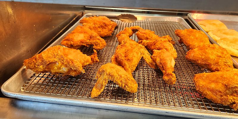 Fresh fried chicken on a wire rack in The Shack kitchen